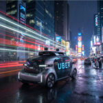 A sleek autonomous Uber robotaxi on a city street at night