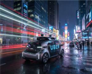 A sleek autonomous Uber robotaxi on a city street at night