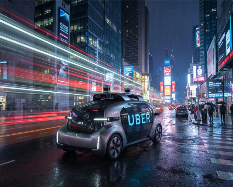A sleek autonomous Uber robotaxi on a city street at night
